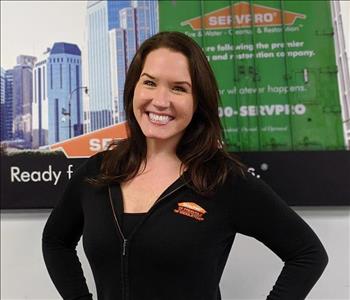 Servpro of Jersey City shares picture of one of their project managers smiling and standing in front of a SERVPRO Ad.
