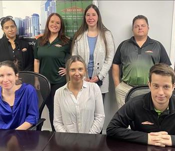 Servpro of South Jersey City and Bayonne  shares their smiling team photo at their office with SERVPRO Ad in the background